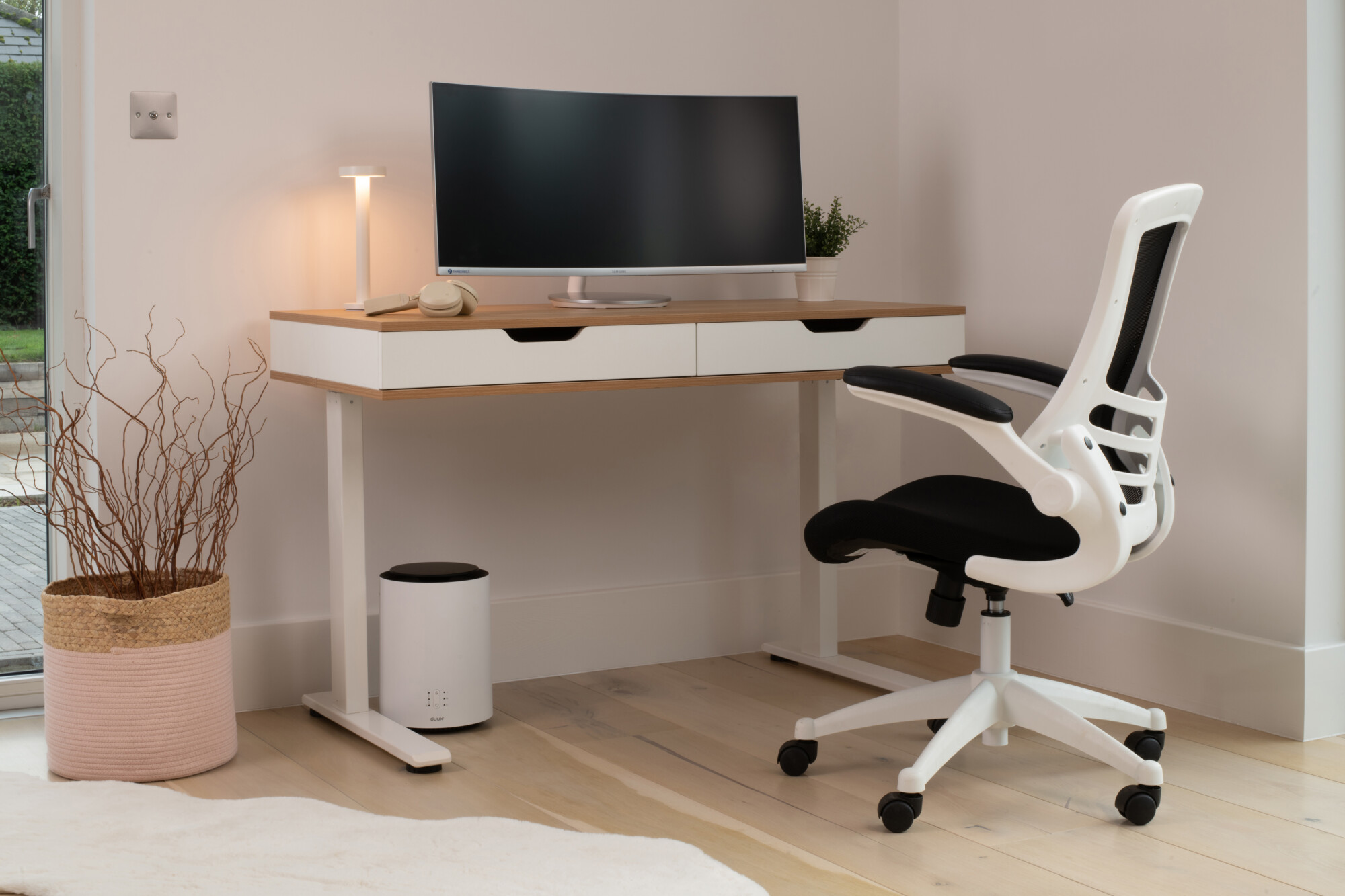 The Ola Height Adjustable Desk With Drawers from Koble Designs, a stylish and modern design that combines maple wood and classic white to create an elegant piece of furniture for your home’s aesthetic. 