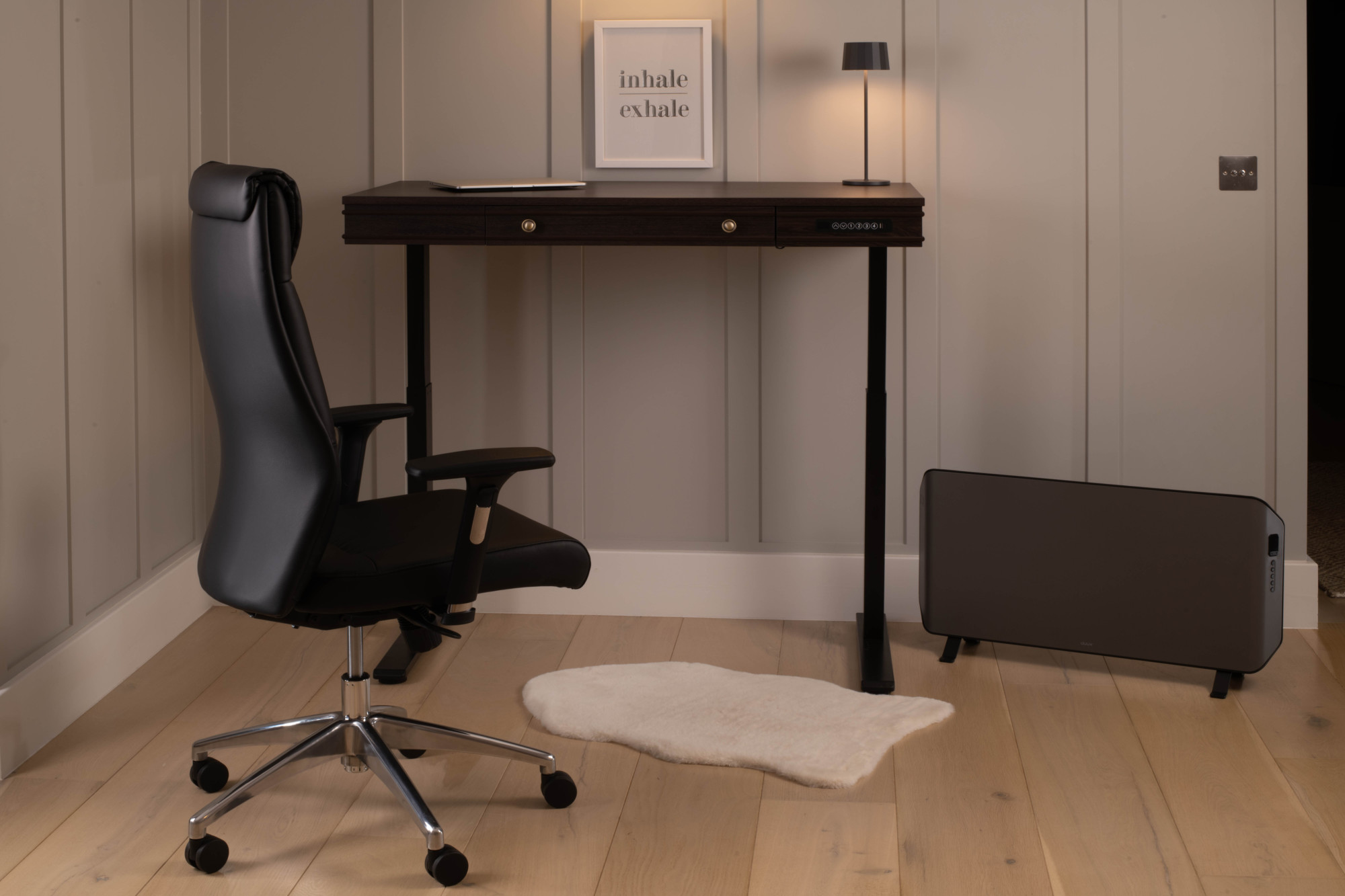 Mahogany and black height standing desk paired with a faux leather executive chair. 