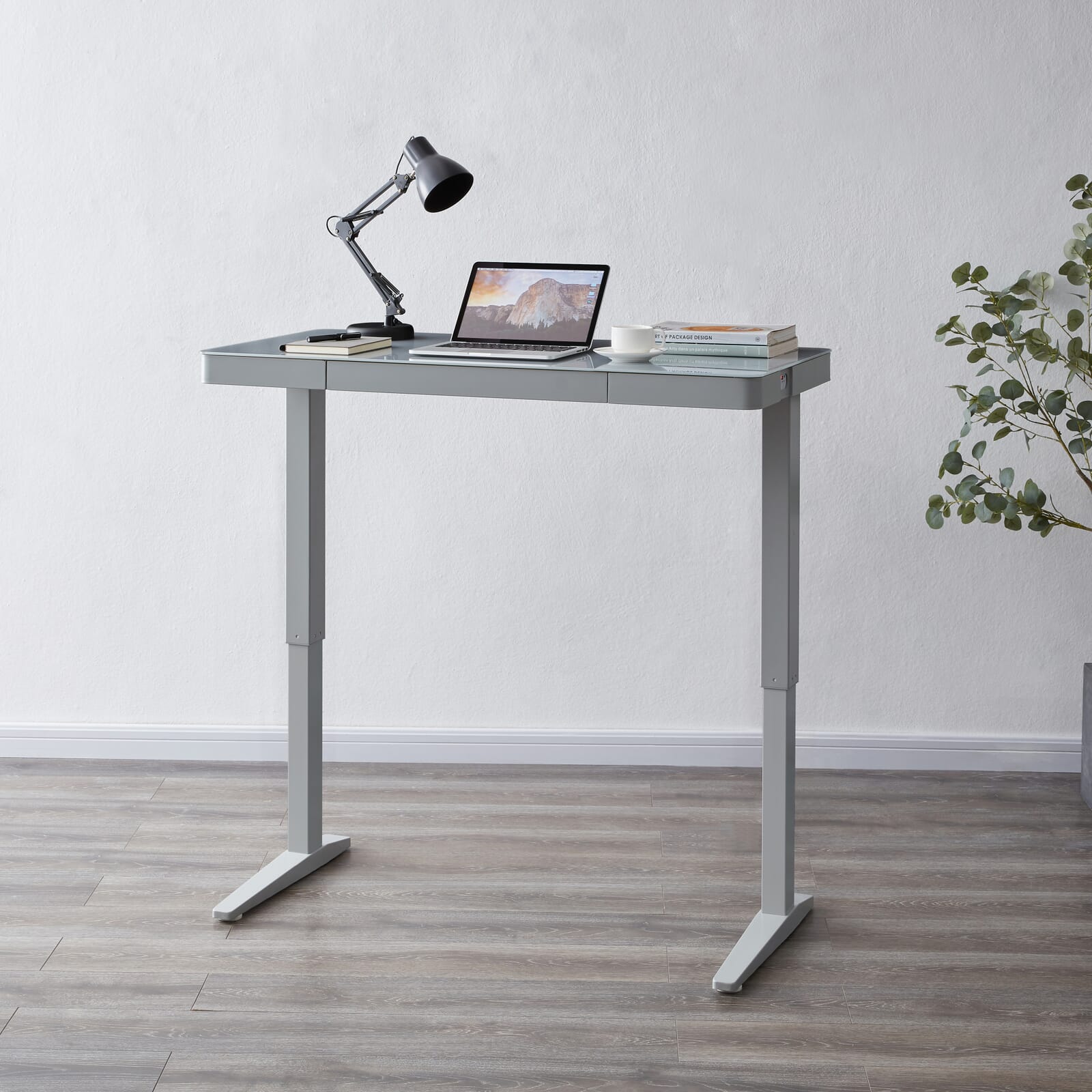 Height adjustable desk in light grey. 