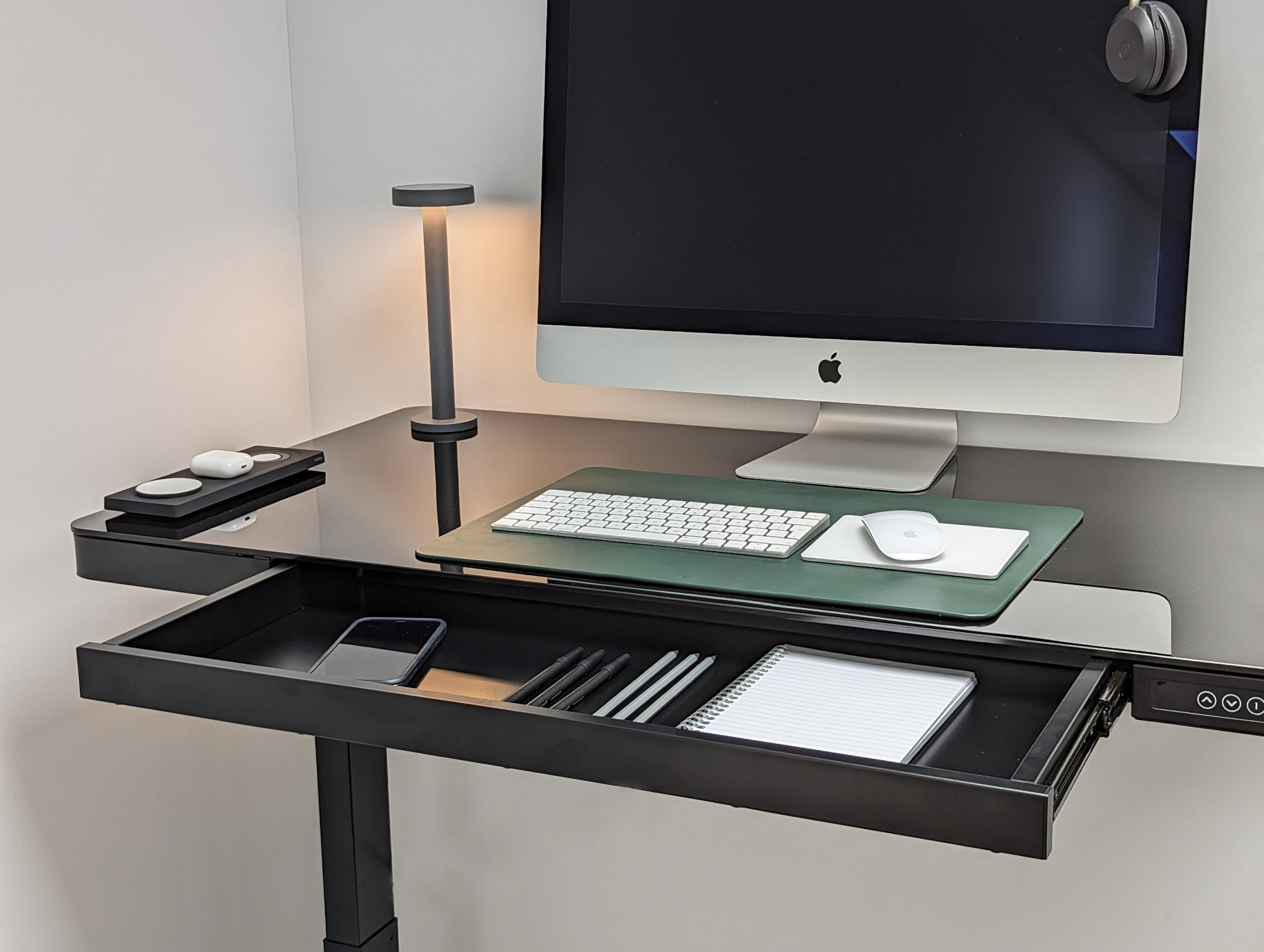 Organised black glass height adjustable desk. 