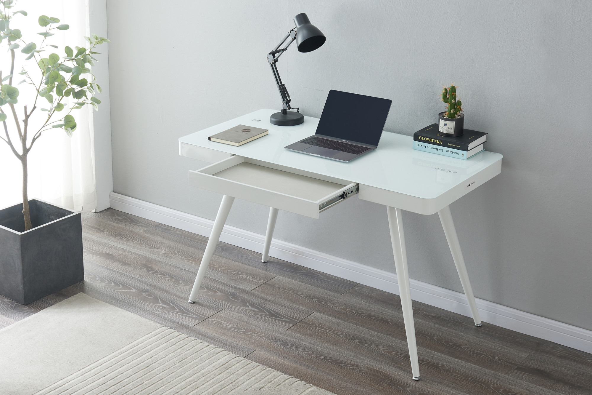 white smart desk with charging points with a laptop and lamp