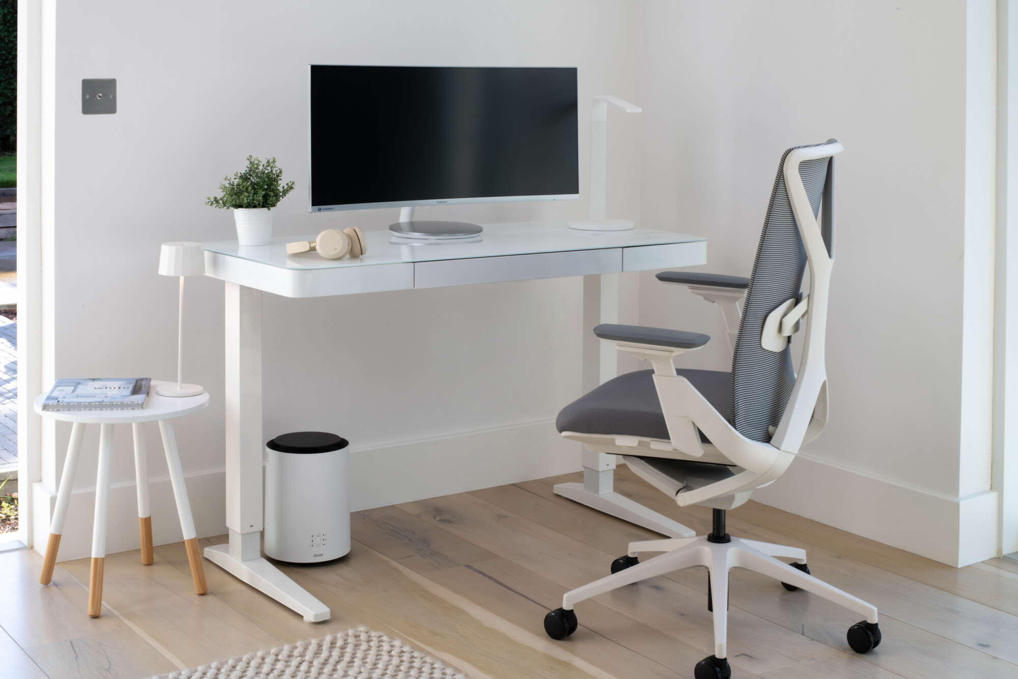 smart home office setup featuring an electric height adjustable smart desk with a whiteboard friendly glass top paired with an ergonomic home office chair.