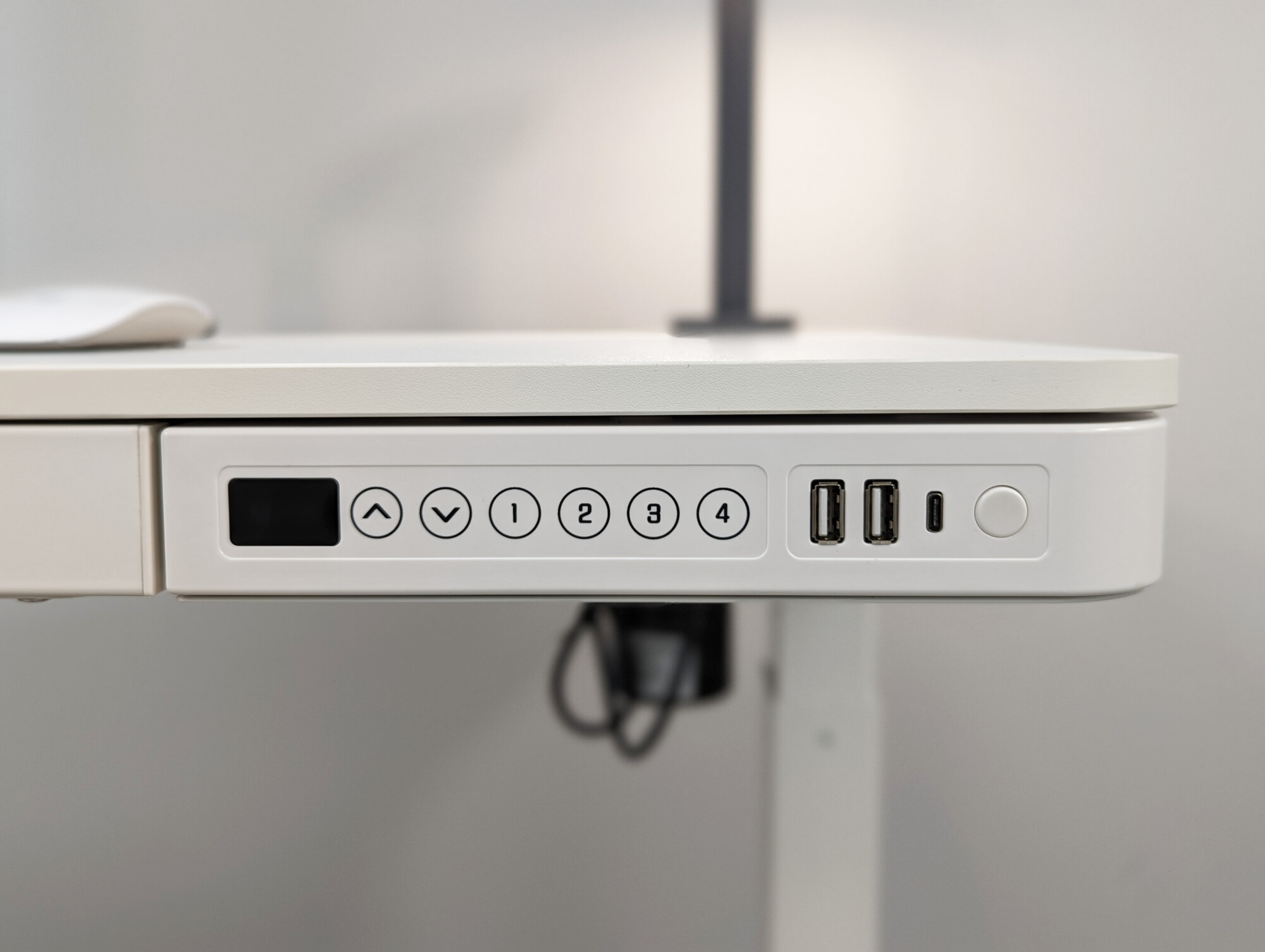 A white MFC Standing desk with height adjustable buttons 